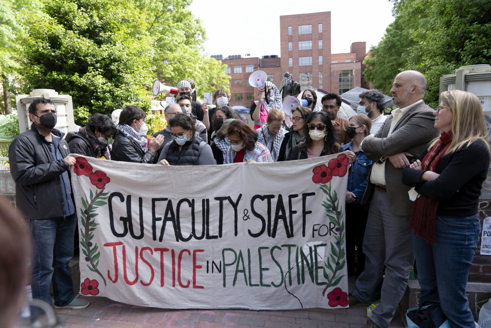 George Washington University professors Rochelle Davis, from right, and Will Youmans lead a group of professors during a pro-Palestinian protest over the Israel-Hamas war on Friday, April 26, 2024, in Washington. (AP Photo/Jose Luis Magana)